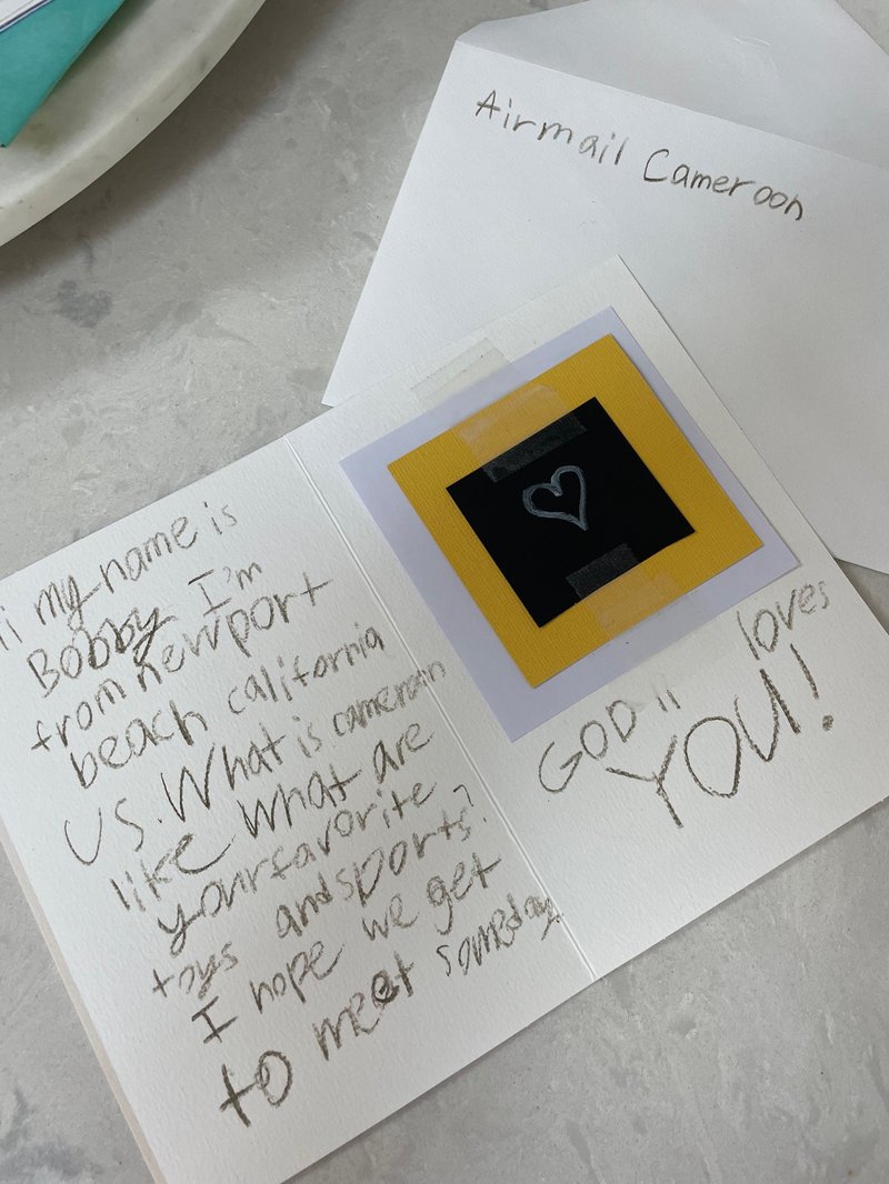 Bobby and Jack with thank you note from children at Rainbow Orphanage