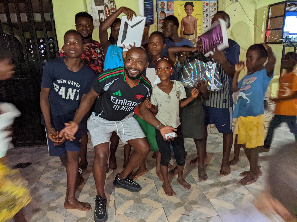 Orock with children at Rainbow Orphanage receiving supplies